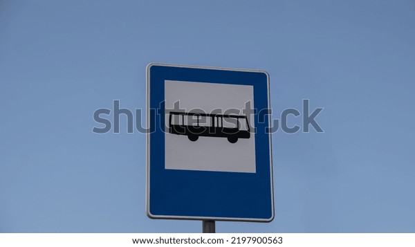 Blue and white bus stop sign in Europe with\
sky background. Bus stop old road sign\
