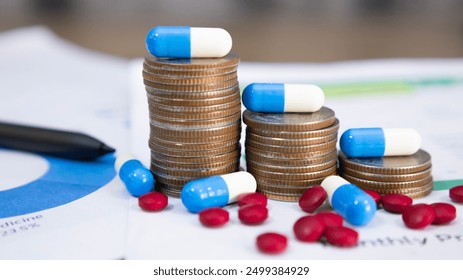 Blue and white capsules on a pile of coins and pills, meaning health insurance, medical expenses and pharmaceutical, finance, saving money, business, financial and medical healthcare concept. - Powered by Shutterstock