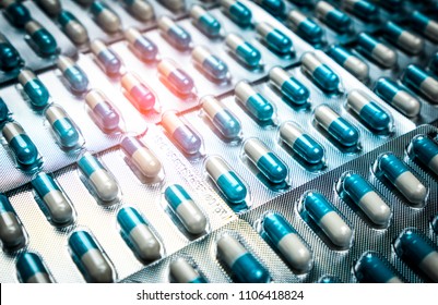 Blue and white capsules pill in blister pack arranged with beautiful pattern. Global healthcare concept. Antibiotics drug resistance. Antimicrobial capsule pills. Pharmaceutical industry. Pharmacy.