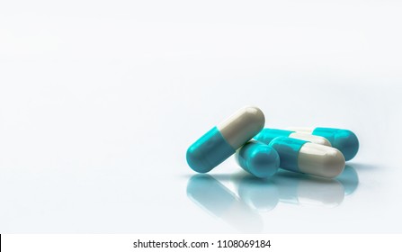 Blue and white capsules pill isolated on white background with shadow and copy space. Global healthcare concept. Antibiotics drug resistance. Antimicrobial capsule pills. Pharmaceutical industry. 