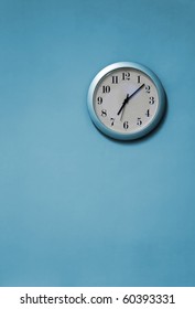 A Blue And White Clock On A Blue Wall