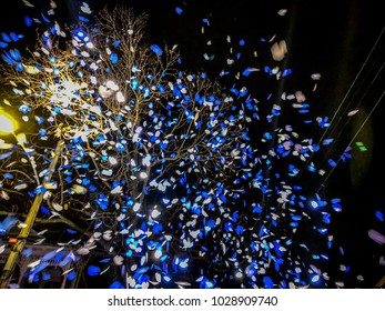 Blue And White Confetti At Night During A Mardi Gras Parade