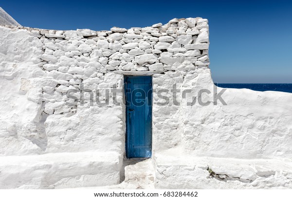 ギリシャのサイクレイズの青と白 海の前の白い壁に青のドア の写真素材 今すぐ編集