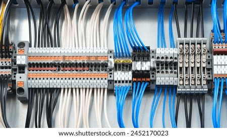 A blue and white electrical box with many wires and a green switch