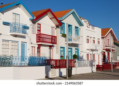 Blue and white facade of house - Palheiro, in Costa Nova do Prado, beach village resort on Atlantic coast, Aveiro, on hot summer day, clean sky, dunes, flowers, window, Portugal