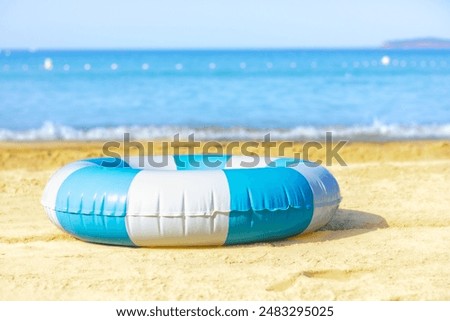 blue and white Inflatable ring on the sand, sea beach, summer background, no people