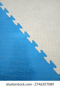 Blue and white interlocking EVA foam floor mats. Textured jigsaw puzzle surface for children's safety and soft indoor play areas.