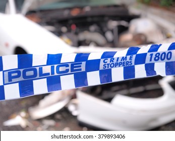 Blue And White Police Tape Cordoning Off A  Crime Scene Area With A Badly Accident Damaged White Car, Australia 2016
