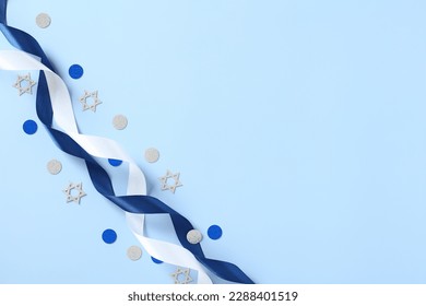 Blue and white ribbons with confetti on blue table. Israel Independence Day, Yom Haatzmaut greeting card design, banner template.