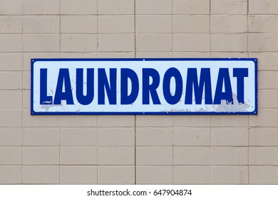 Blue And White Sign For A Laundromat, On A Concrete Wall