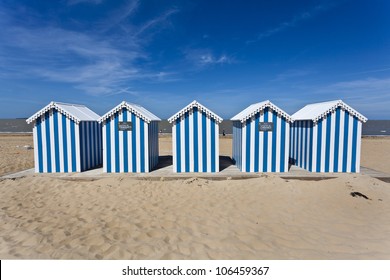 Blue and white striped beach houses on a sunny beach in France, Europe - Powered by Shutterstock