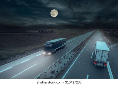 Blue And White Truck In Motion Blur On The Highway At Night With Moon.