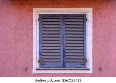 Blue window shutter and pink wall