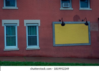 
blue windows, a wall of red bricks and a yellow panel on the wall.