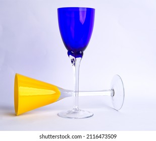 A Blue Wine Goblet Paired With Yellow Martini Glass With A White Background. 