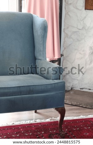 Blue wingback chair, red rug