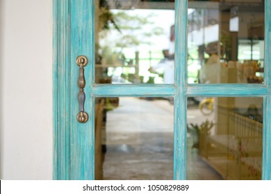 Blue Wooden Door And Glass With Steel Hand Lock At The Entrance Of Restaurant.