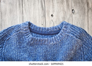 A  Blue Wool Jumper On A Wood Surface