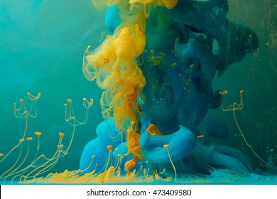 Blue Yellow Color Drop In Water In Motion. Ink Clouds Swirling. Cloud Of Acrylic Ink Under Water Paint Background. Colorful Ink In Water Paint Drops.