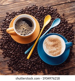 Blue and yellow cups of coffee,  spoons, coffee beans  on a wooden background - Powered by Shutterstock