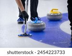 Blue and yellow curling rocks during play.