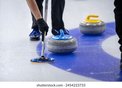 Blue and yellow curling rocks during play.