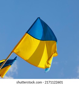 The blue and yellow flag of Ukraine flutters in the wind on a windy day.
