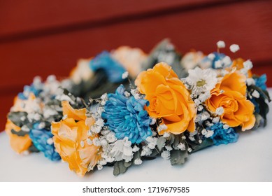 Blue and yellow flowers in a swedish midsummer crown with a red background 