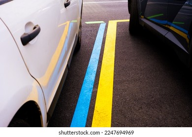 Blue and yellow lines to delimit paid car parks zone in lot. - Shutterstock ID 2247694969