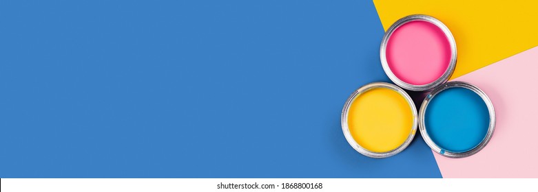 Blue, yellow, pink background with three colors paint cans. Flat lay, top view, copy space. - Powered by Shutterstock