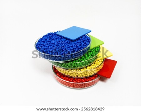 Blue, yellow, red and green masterbatch plastic granules, colorful polymer pigment granules isolated on white background, for product catalog design of plastic manufacturing industry company profile
