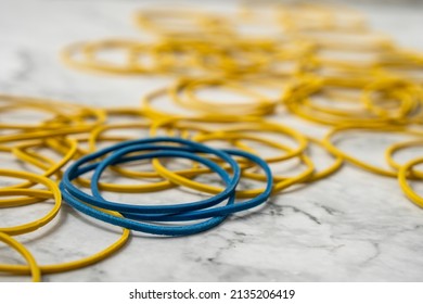 Blue and yellow rubber bands on table.