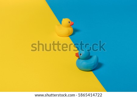 Blue and yellow rubber duck with blue and yellow background. Copy space. Minimal opposite concept