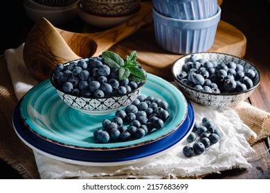 Blaubeeren in Schalen mit Tellern über dem Tisch - Nahaufnahme