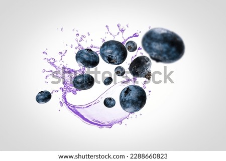 blueberries falling into a splashing purple juice