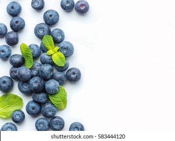 Blueberries isolated on white background. Blueberry border design. Ripe and juicy fresh picked bilberries close up. Copyspace. Top view or flat lay