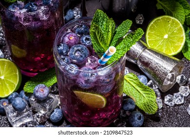 Blueberry citrus summer cooling drink, iced berry mojito lemonade cocktail with blueberries, mint and lime