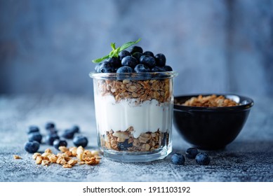 Blueberry Greek yogurt granola parfait in a glass. toning. selective focus