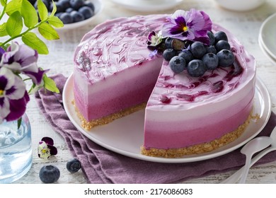 Blueberry layered cheesecake, no baked ombre mousse cake, decorated with fresh berries and edible viola flowers