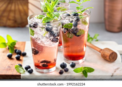 Blueberry mojito in tall glasses with mint, refreshing summer berry drink