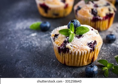 Blueberry muffins with powdered sugar and fresh berries