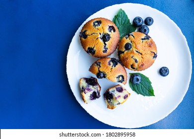 Blueberry Muffins In White Plate On Blue Background With Copy Space