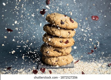 Blueberry And Oatmeal Cookies Stacked While Falling Blueberry And Oatmeal Flakes From Above - Cookies At An Ingredient Party