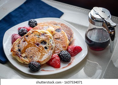 Blueberry pancakes with blueberry syrup and fresh berries