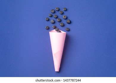 Blueberry In Pink Paper Cone On Blue Background