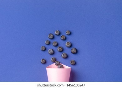 Blueberry In Pink Paper Cone On Blue Background