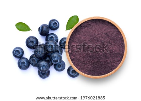 Blueberry powder in wooden bowl and fresh blueberries fruit isolated on white background. Top view. Flat lay.