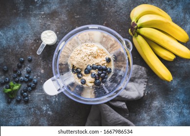 Blueberry protein powder in blender, smoothie preparation, top view. Concept of fitness healthy eating, clean eating, sport lifestyle