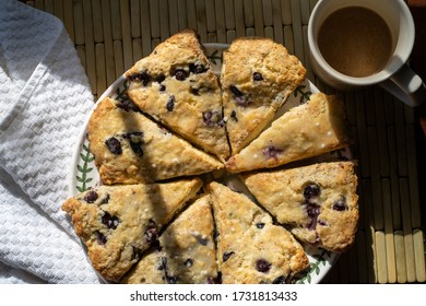 Blueberry scones cut in triangles on a round plate with a cup of hot drink.  - Powered by Shutterstock