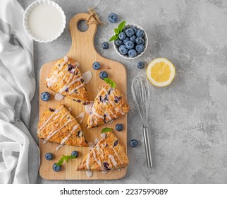 Blueberry scones with lemon glaze on top on a gray concrete background. Delicious breakfast - Powered by Shutterstock